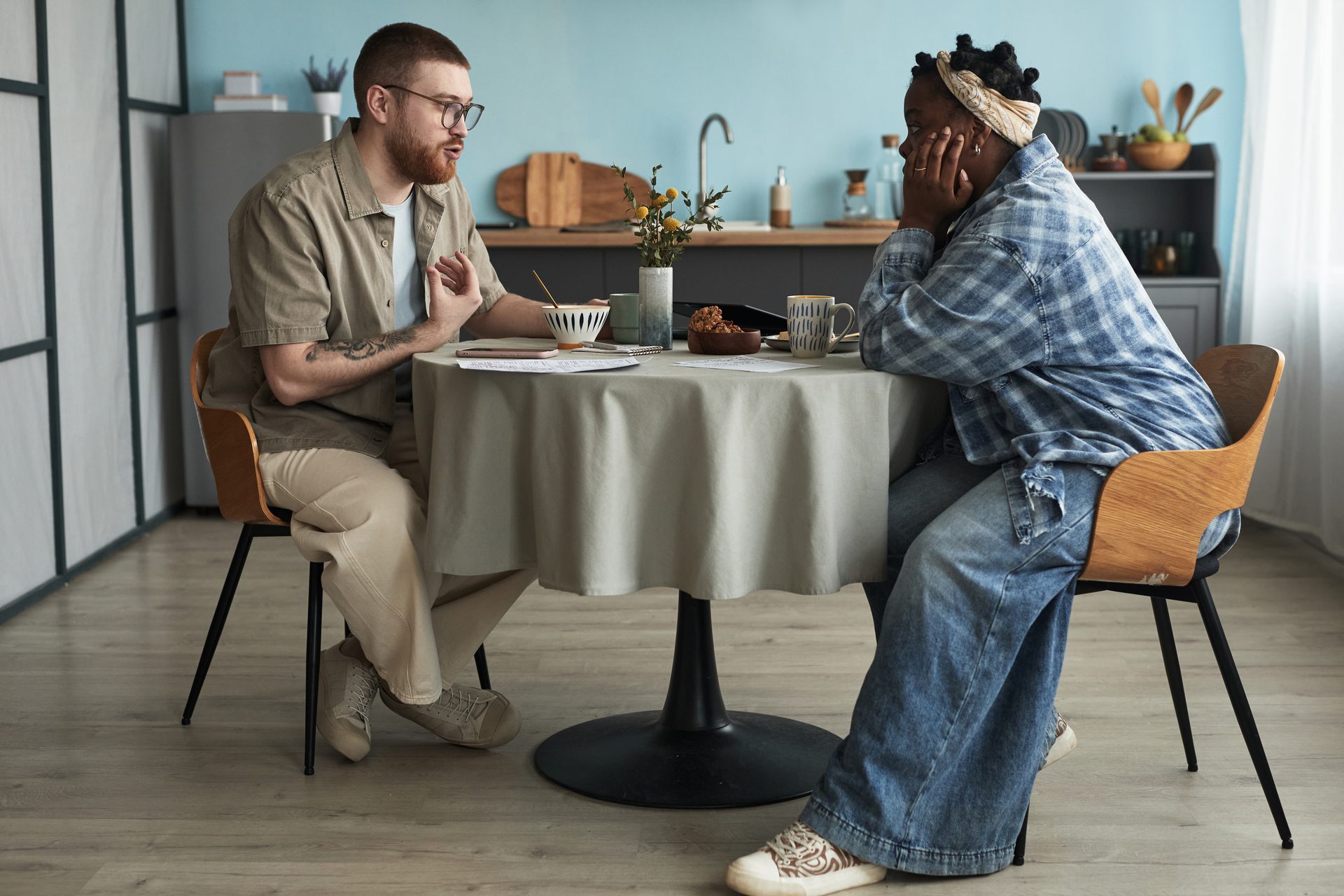 Diverse pair in difficult conversation at table